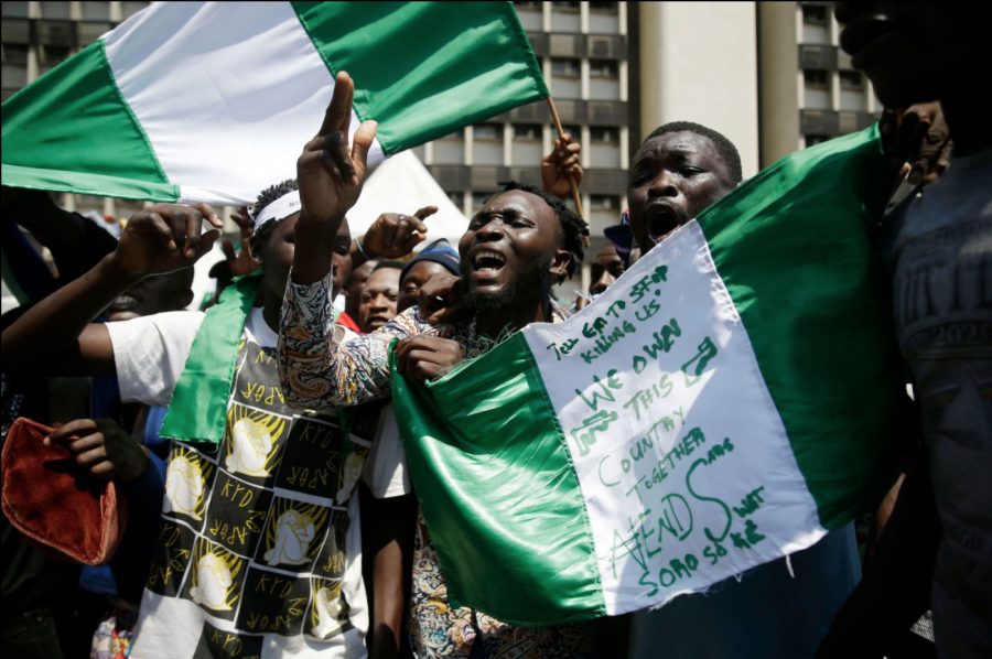 People hold banners and flags as they protest in Lagos, Nigeria, on October 20