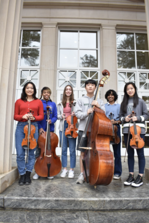 Selected All-state orchestra students stand in front of Pressly Hall. 